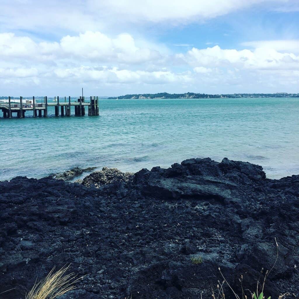 Black rock shore with blue water