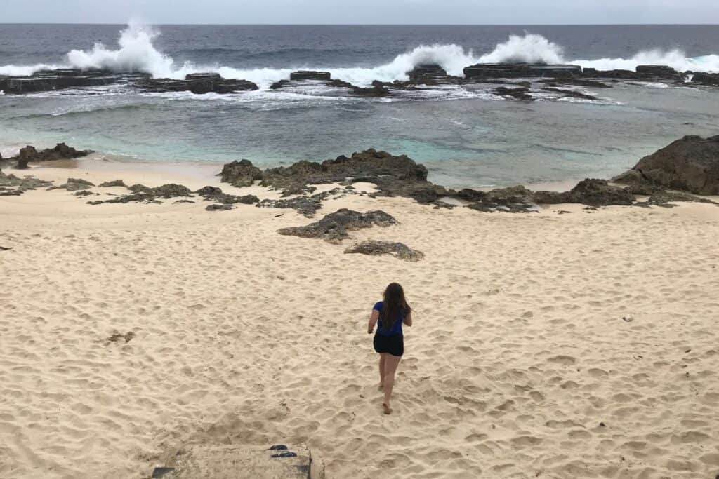 Girl running on a secret beach you can find when you visit tonga