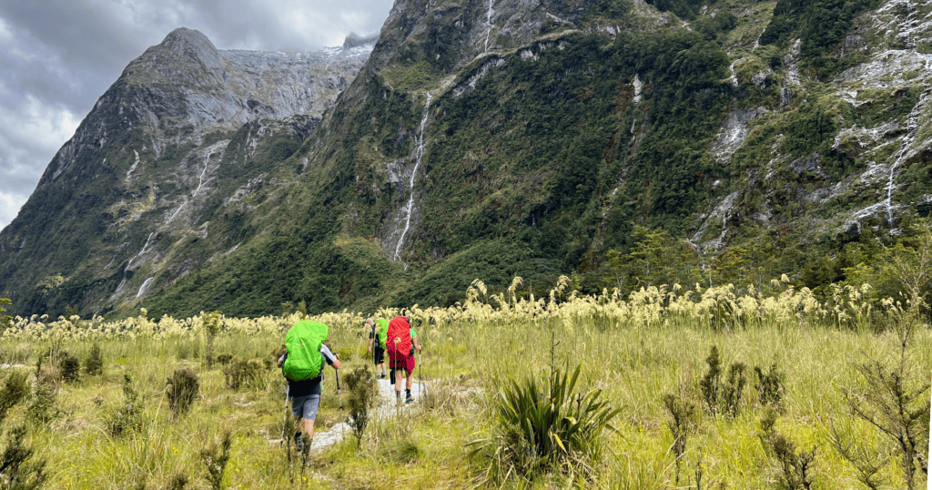 Hikers Walking Through Rain with Mountains