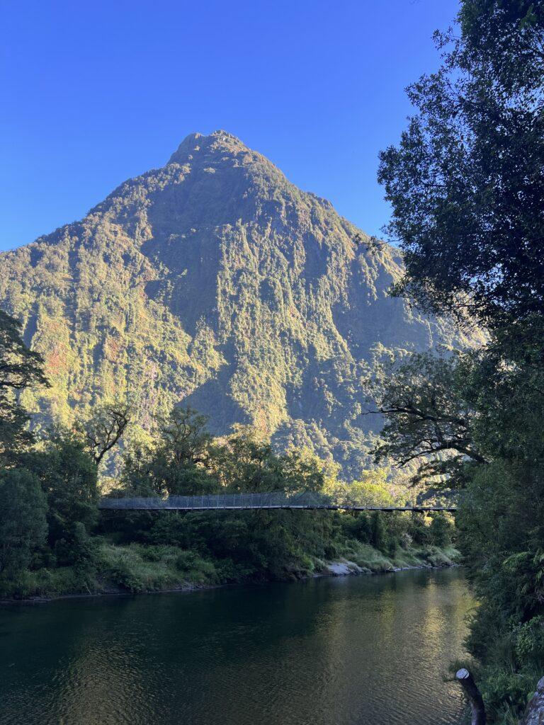 Mountain, river, and bridge visible on the Milford Track