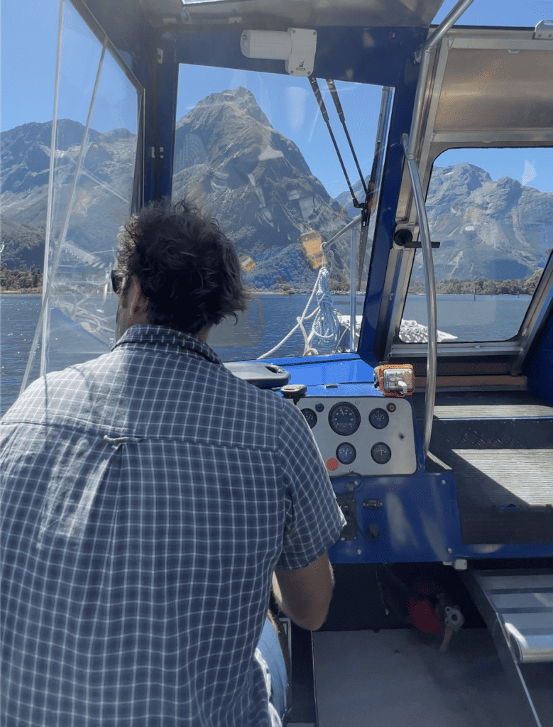 Man driving a boat in Milford Sound