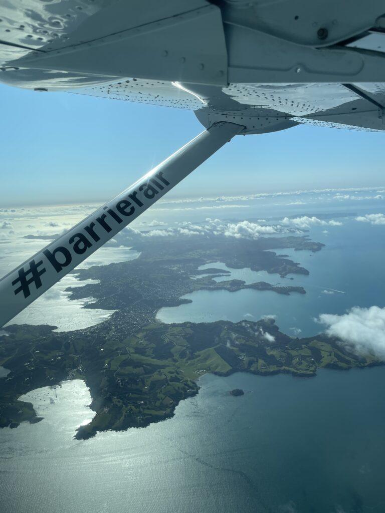 Small plane flying over islands between Auckland and Great Barrier Island