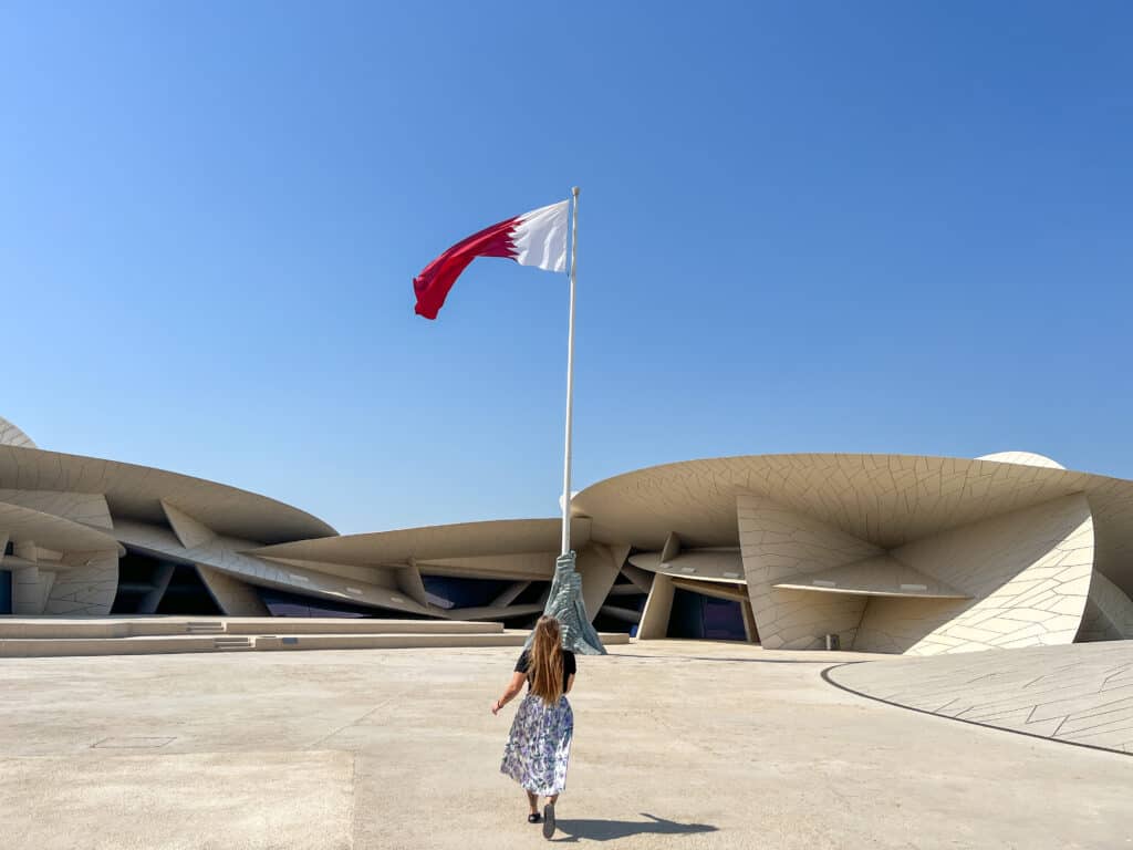 Girl running towards the Qatari flag