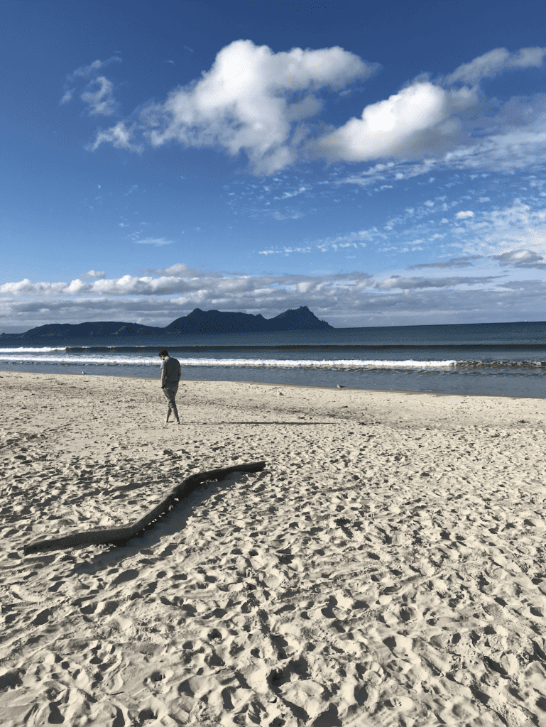 Man walking along Ruakaka beach