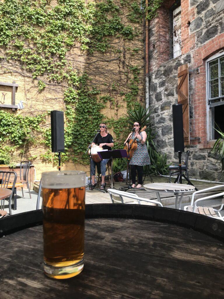 Two musicians play in an outdoor seating area