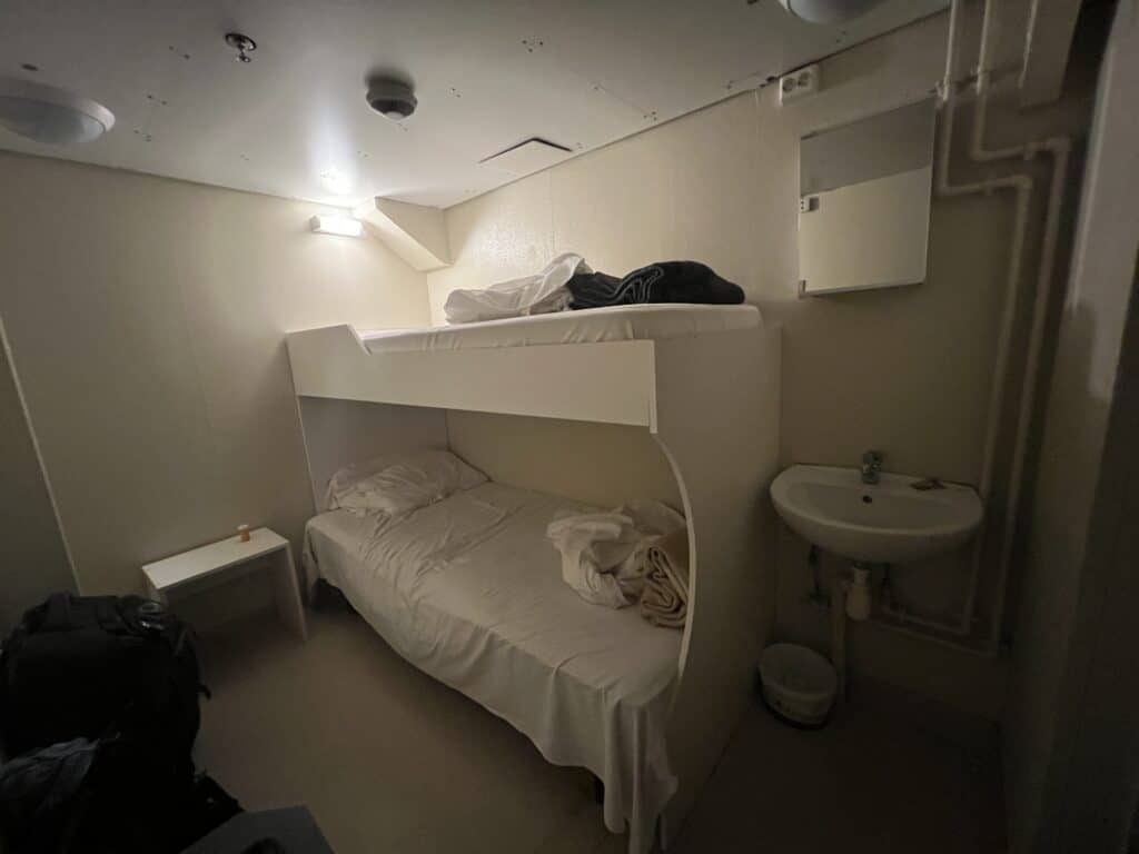 One bunk bed and a sink in a room with no windows