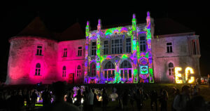 Transylvanian castle at night with colourful light projections on the exterior