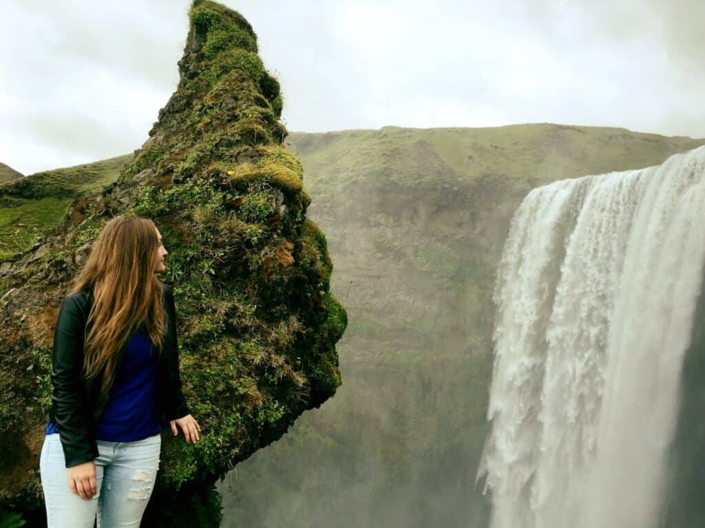 Girl Looking at a famous Iceland waterfall in summer