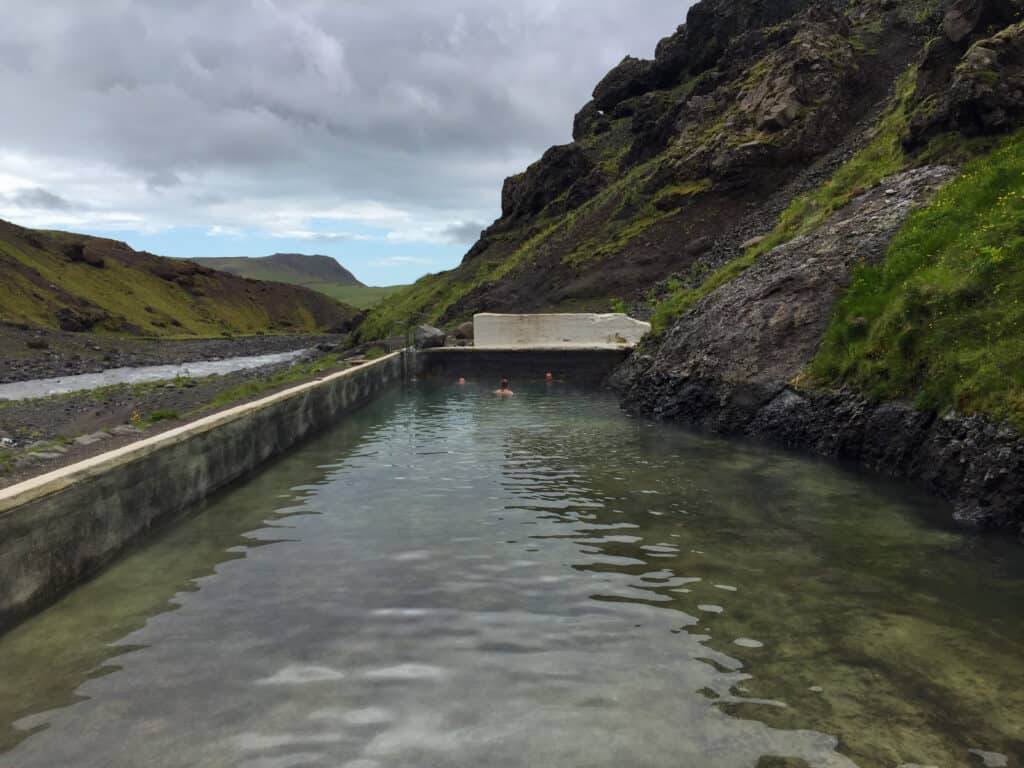 People swimming at secret hot spring in Iceland