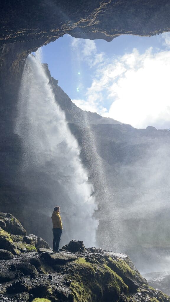 Man standing in front of waterfall