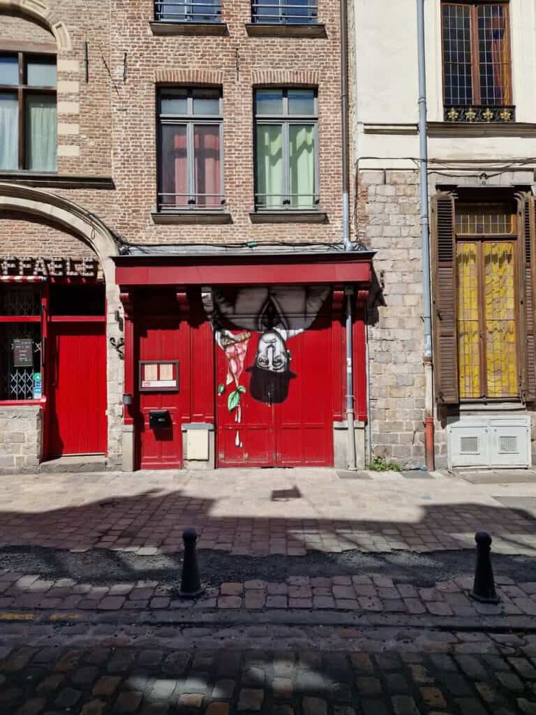 Artistic red door with an upside down man painted on in France