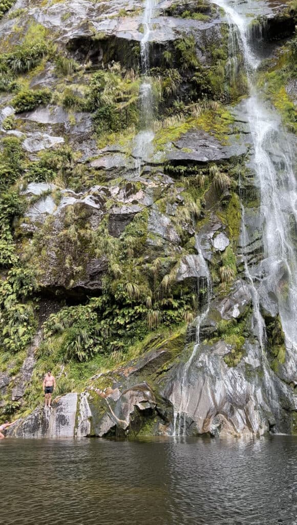 Man standing at the bottom of a waterfall