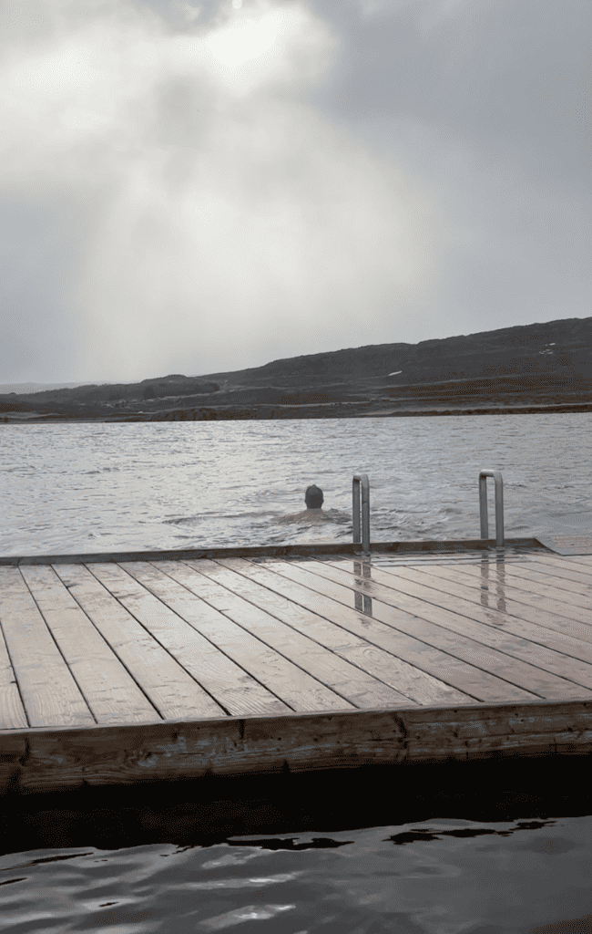 Man swimming in a lake - Vok Baths hot springs in Iceland