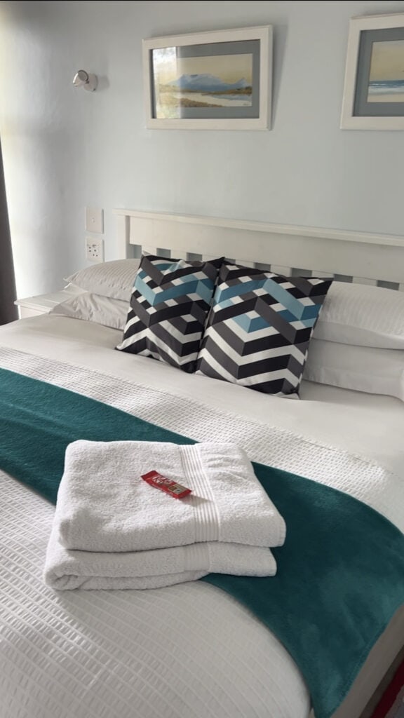 Airbnb bedding with towels and chocolate