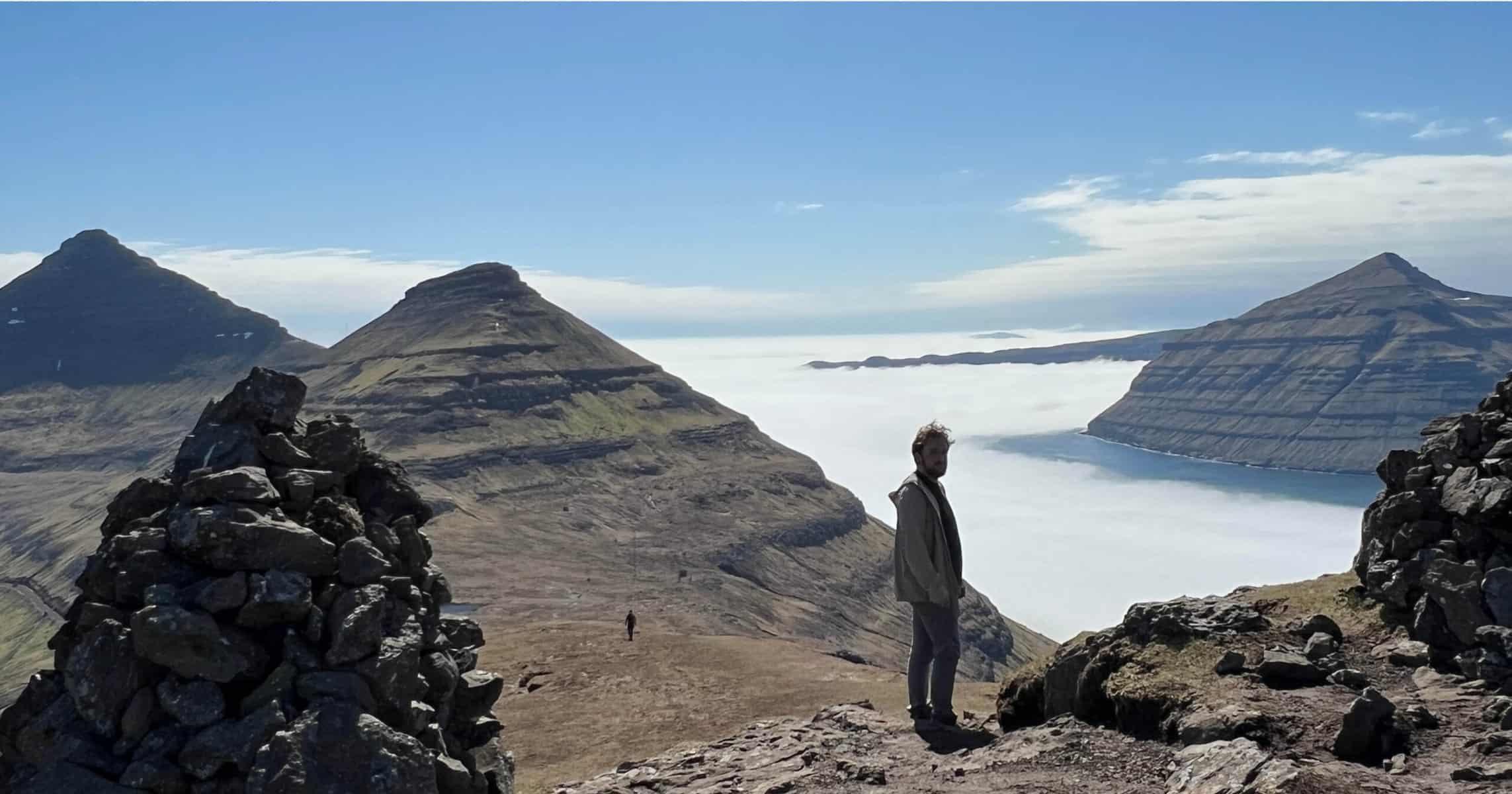 Man above the clouds hiking in the Faroe Islands