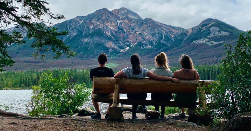 Four people sitting on a bench in Jasper, Canada