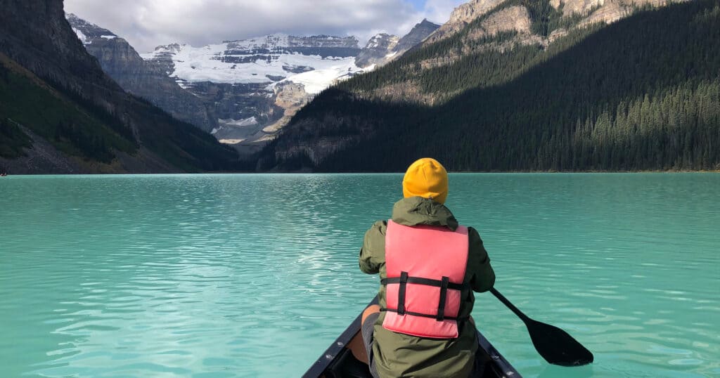 Man in yellow hat canoeing at Lake Louise, Canada