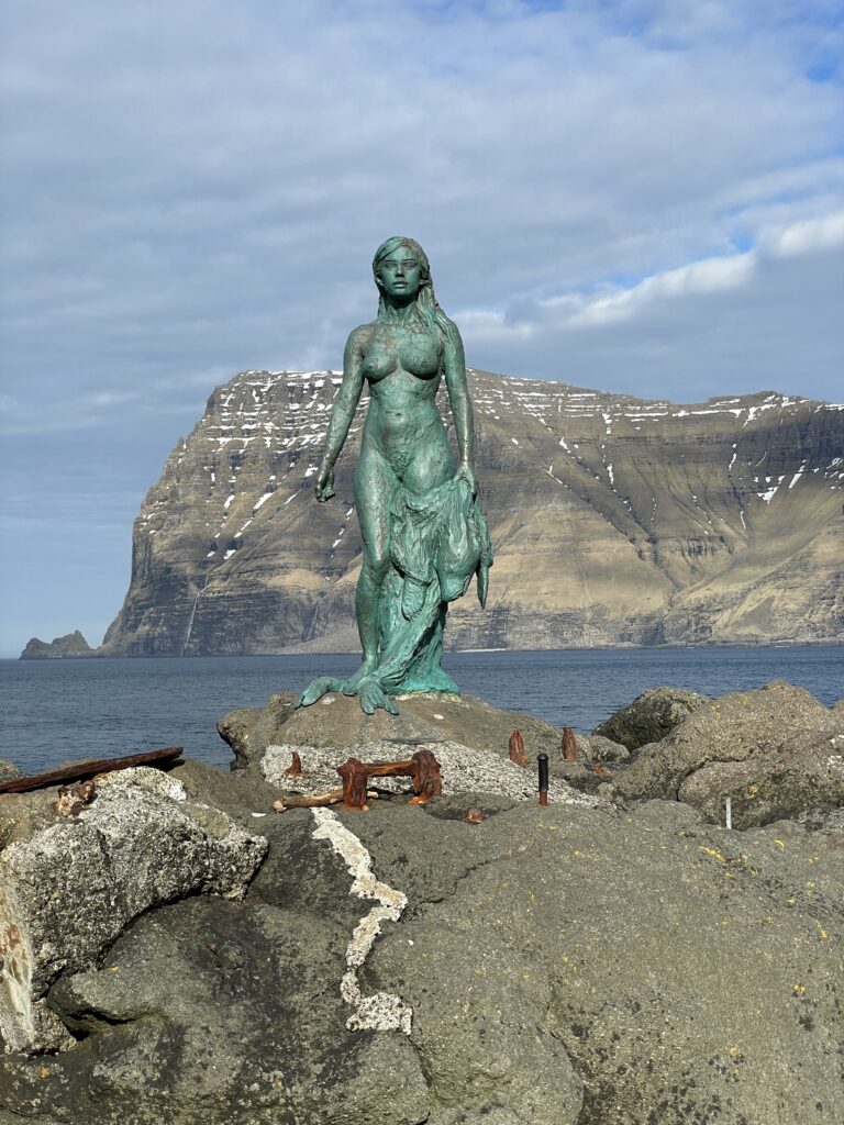 Green seal woman mermaid statue in the faroe islands