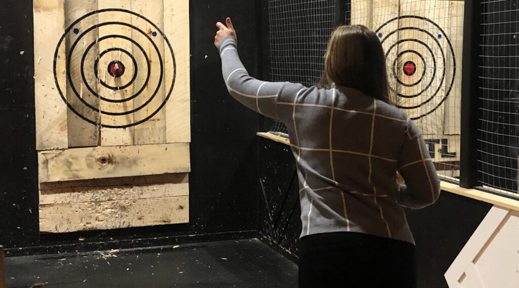 Girl throwing axe throwing