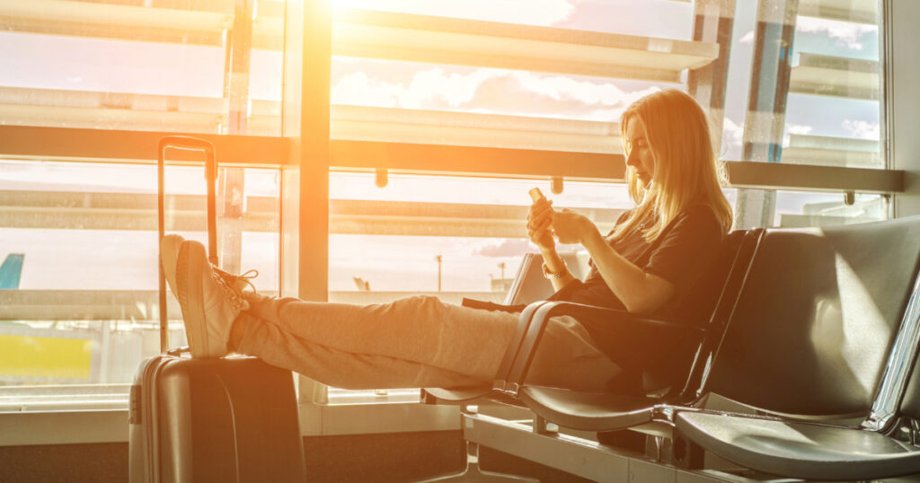 Woman using her phone at the airport esim