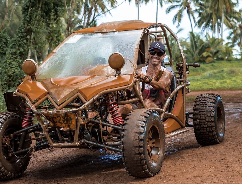 Muddy person driving a buggy in Rarotonga on a rainy day