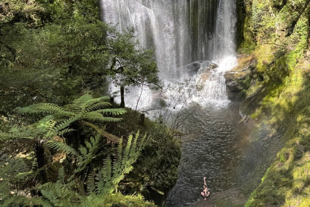Woman swimming at Korokoro Falls, New Zealand