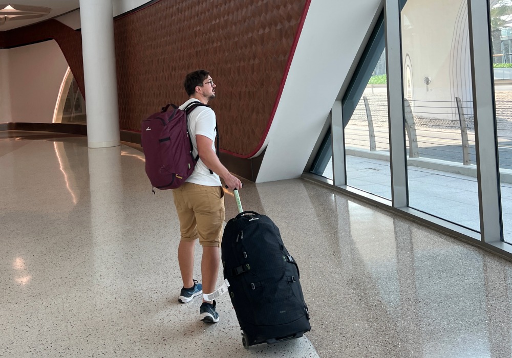 Rolling a suitcase through the Doha airport towards the metro