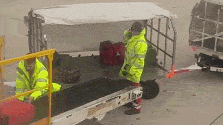 Baggage handlers at the airport tossing luggage