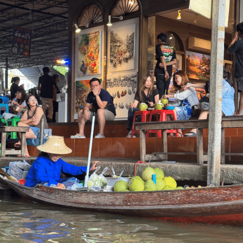 Boat vendor at Danoen Saduak Floating Market near Bangkok with coconuts