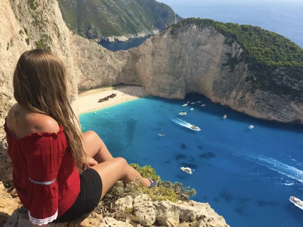 Girl looking over shipwreck beach, Greece